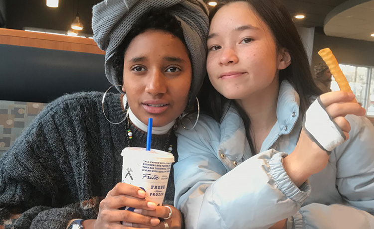 Alemitu and a friend pose with their meals in a booth at Culver’s.