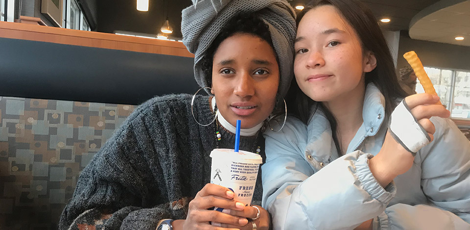 Alemitu and a friend pose with their meals in a booth at Culver’s.