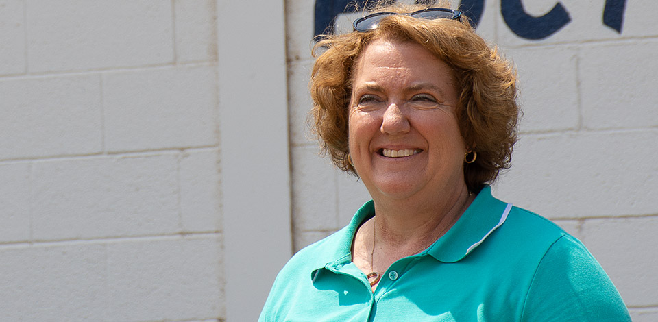 NCBA President Jennifer Houston poses in front of a livestock barn.