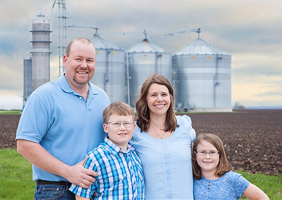 Katie Pratt with her family standing in front of her farm.