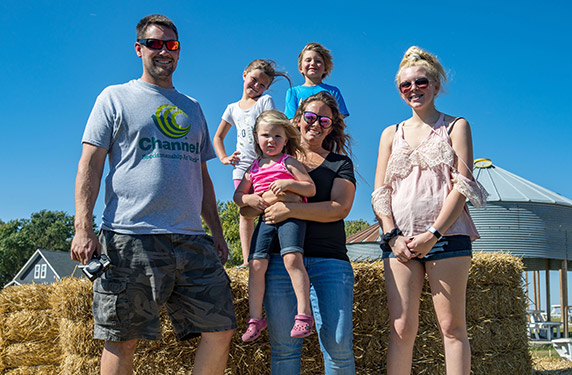 Zach and his family posing for a photo on their farm.