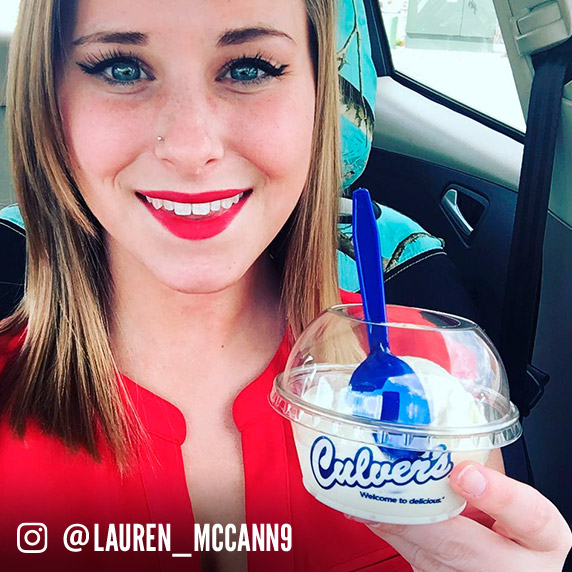 A woman holds up a scoop of Culver’s Vanilla Fresh Frozen Custard.