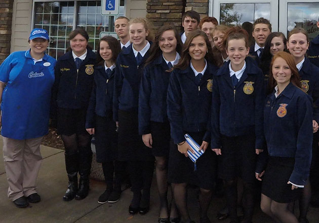 Link to story: How Culver's Restaurants Support FFA Chapters. Large group of FFA Students and Culver's Team Members posing in front of doors to Culver's Restaurant